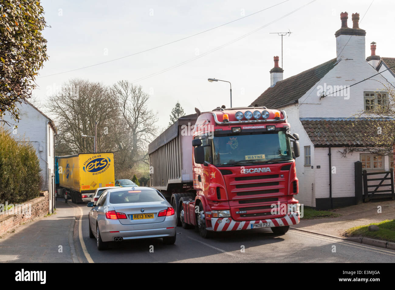 Traffic congestion with HGV lorries and cars passing close to houses in the rural village of Rempstone, Nottinghamshire, England, UK Stock Photo