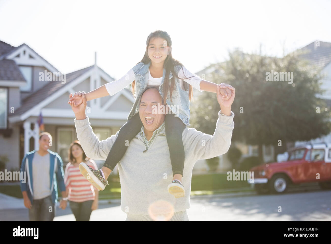 Portrait of grandfather carrying granddaughter on shoulders Stock Photo
