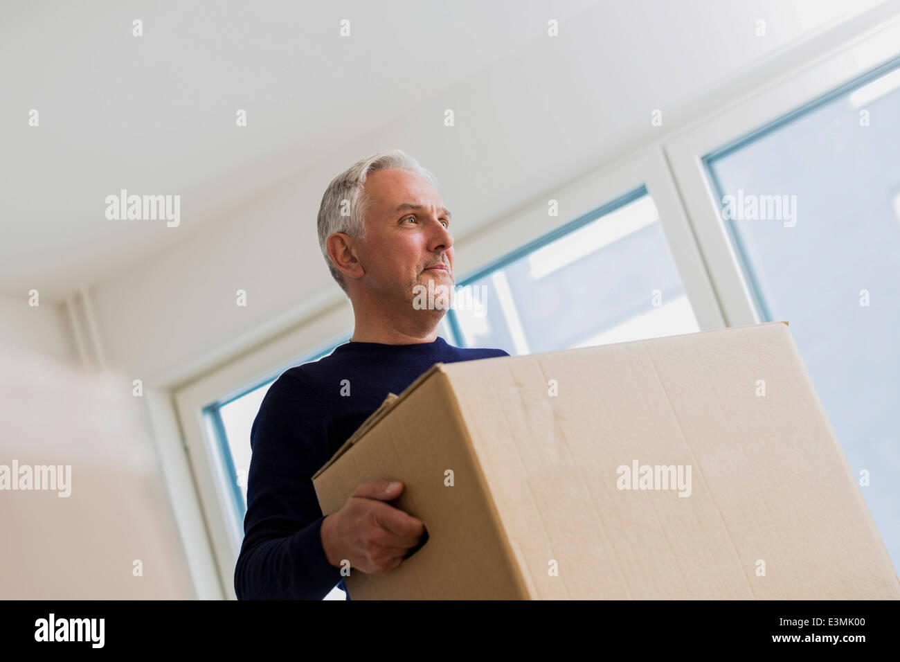 Mature man carrying moving box at home Stock Photo - Alamy