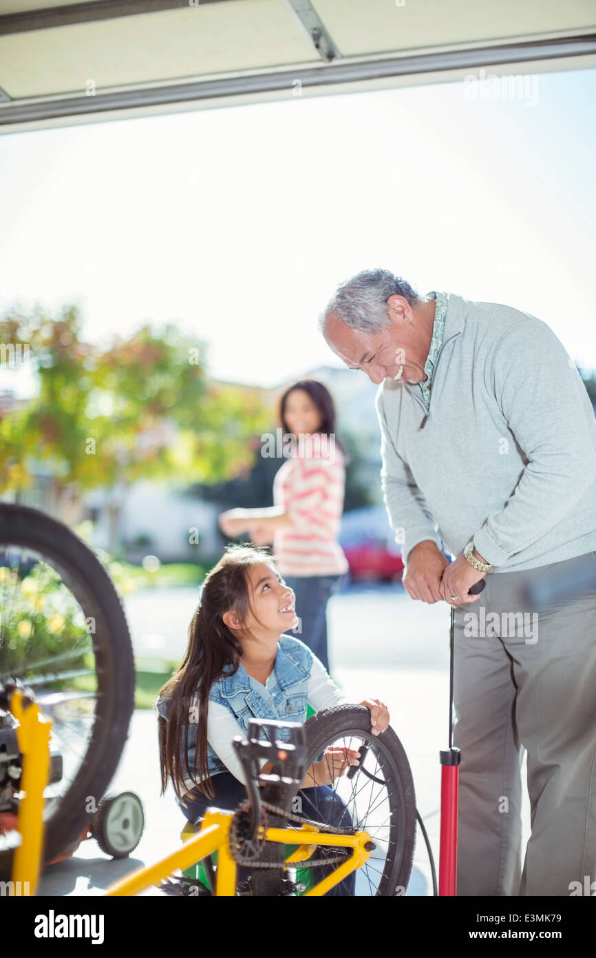 Grandfather and granddaughter inflating bicycle tire Stock Photo