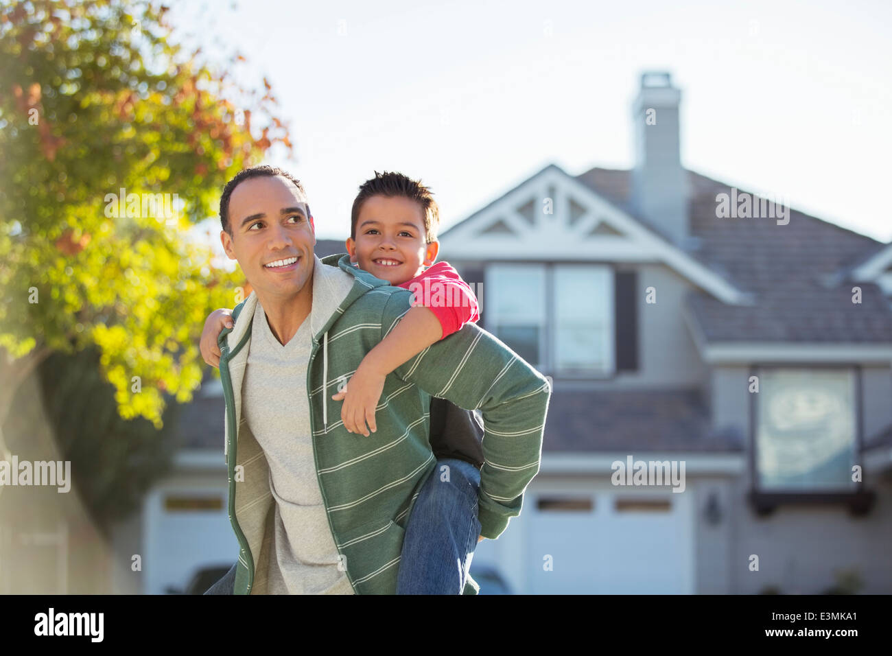 Father piggybacking son outdoors Stock Photo