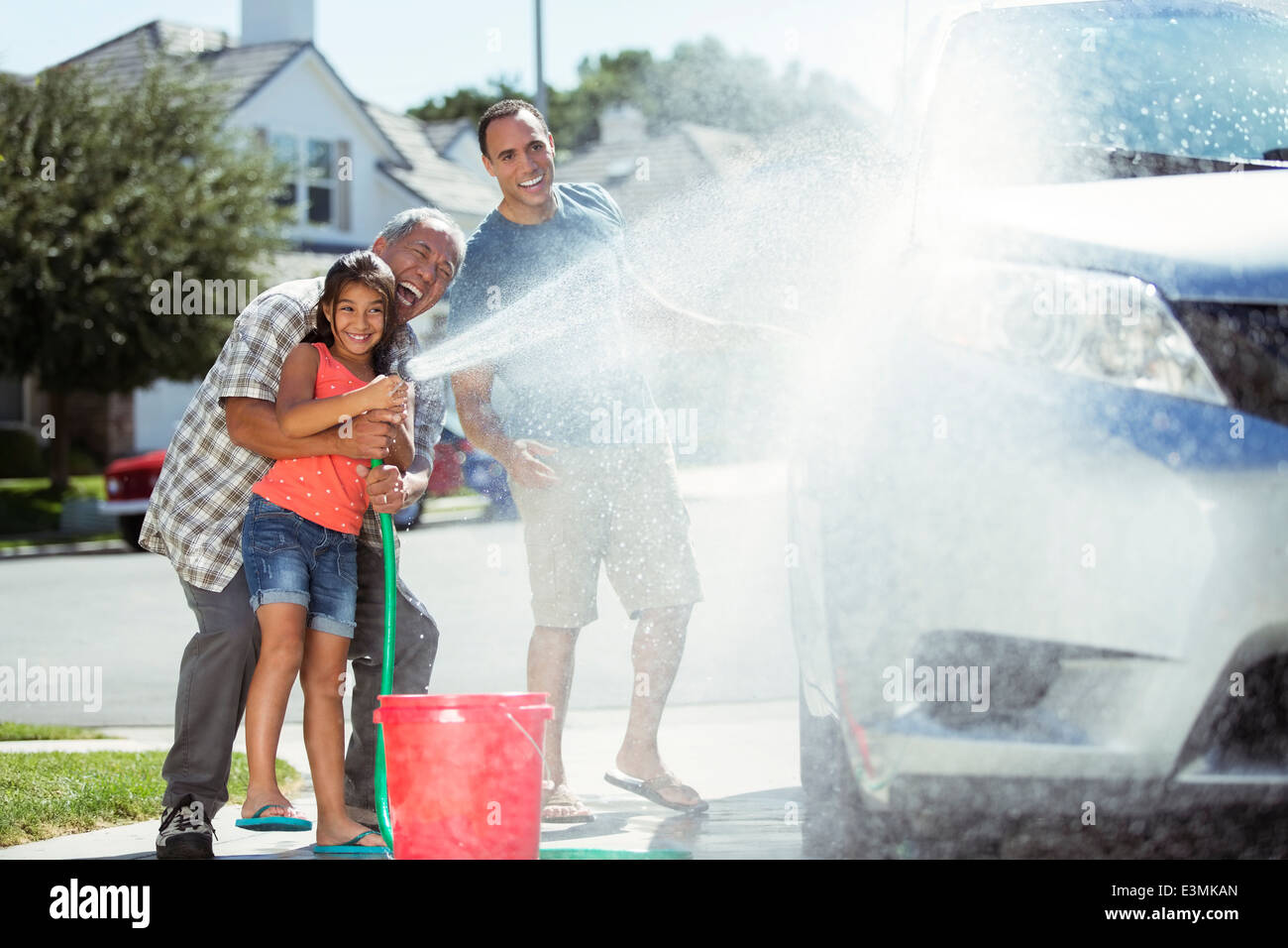 Multigeneration family washing car in driveway Stock Photo Alamy