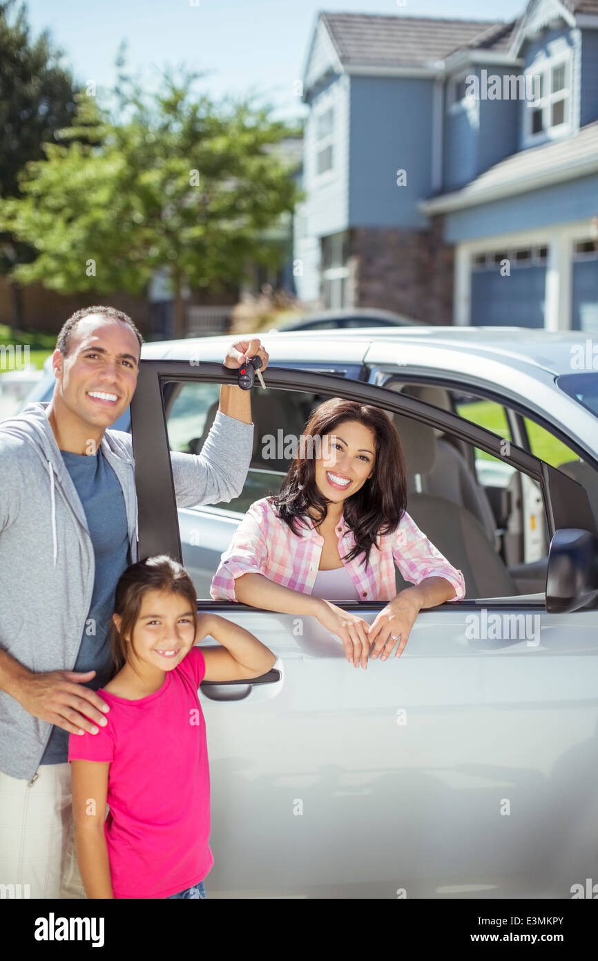 Portrait of smiling family at car in driveway Stock Photo