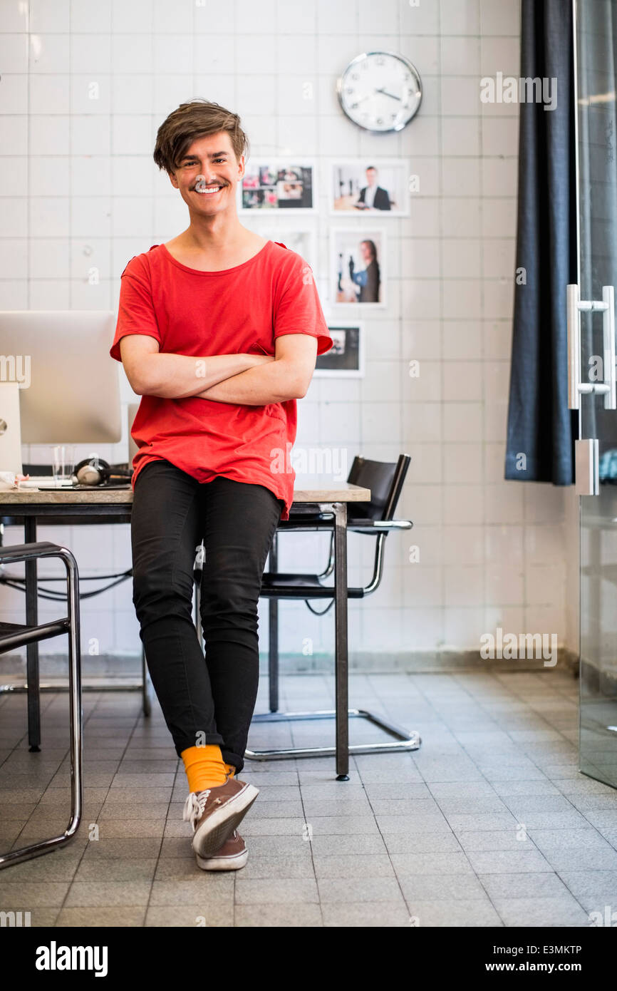 Full length portrait of smiling young businessman with arms crossed in ...