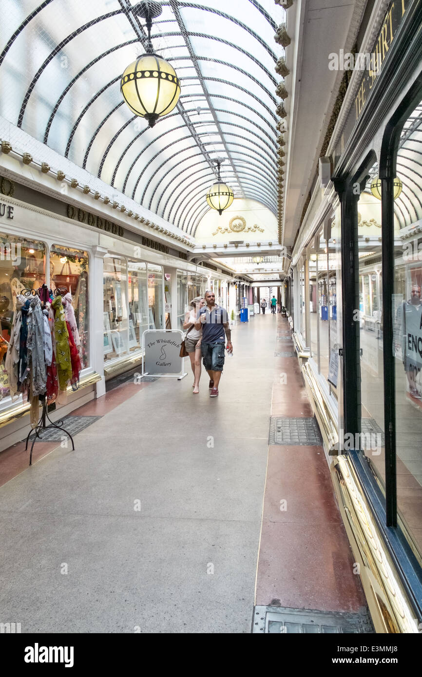 A couple stroll down The historic Corridor covered shopping arcade in Bath, Somerset, UK Stock Photo