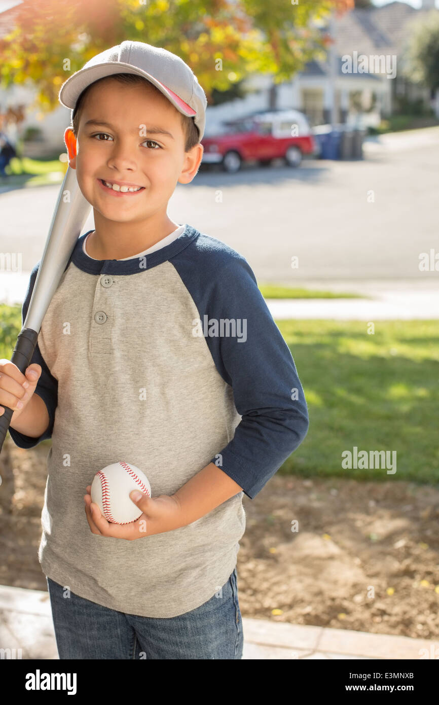 Portrait of smiling boy with baseball and bat Stock Photo