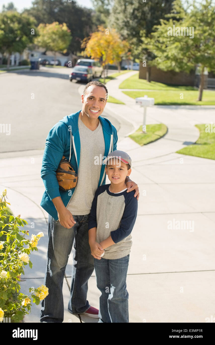 Portrait of smiling father and son in driveway Stock Photo