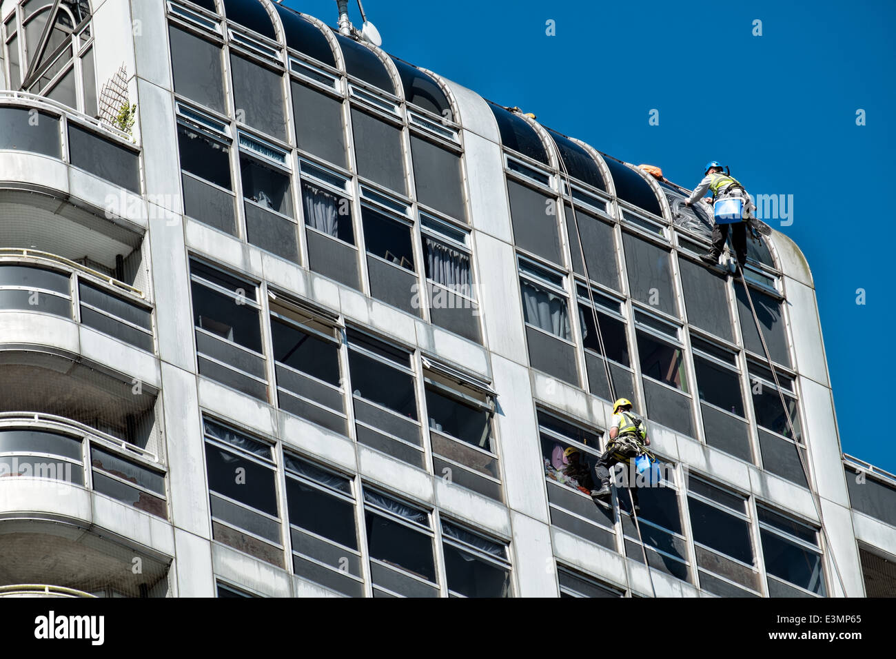 Window cleaners cleaning windows on the David Murry John building and Brunel shopping Center logo, Swindon, Wiltshire, UK Stock Photo