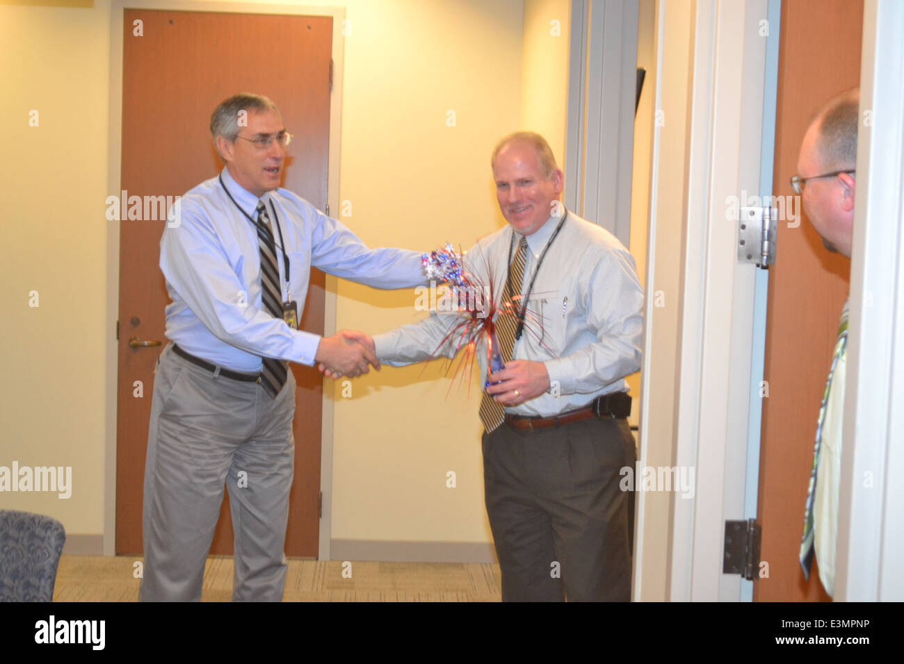 Regional Director Tom Melius passes the torch to Gary Young signifying the beginning of the games. Stock Photo