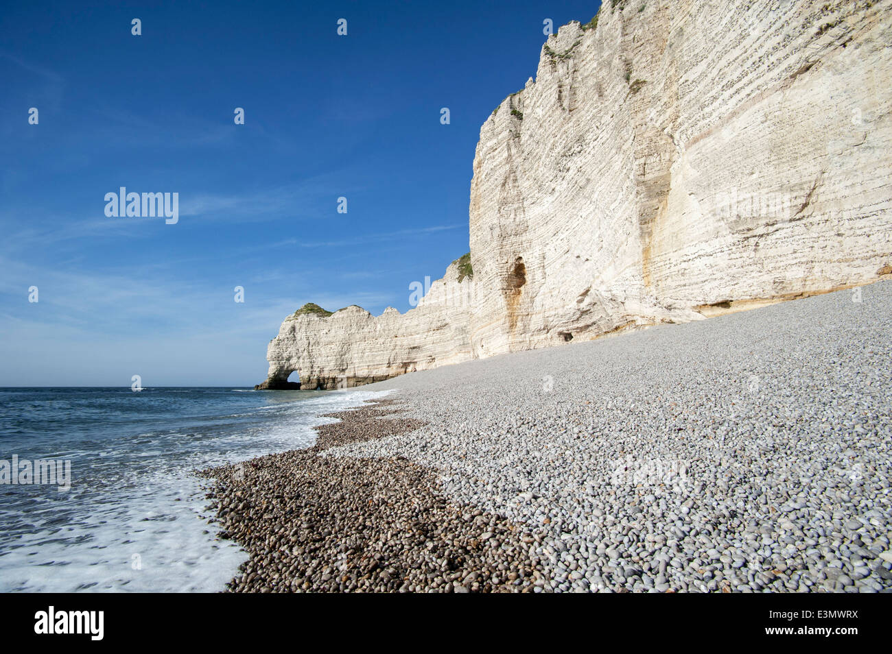 Shingle beach and the natural rock arch porte d'Amont at Etretat, Normandy, France Stock Photo
