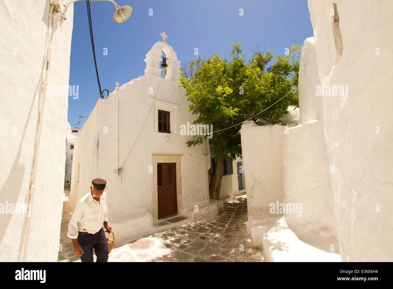 Typical local man and church in Mykonos town,Greece. Stock Photo