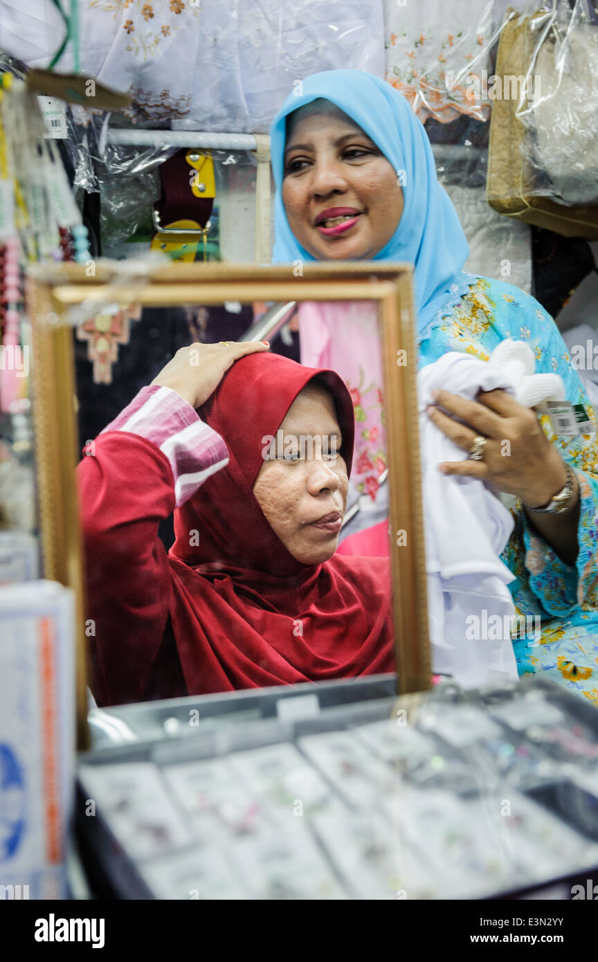 Muslim women buying headscarfs, Kuchng, Malaysia Stock Photo