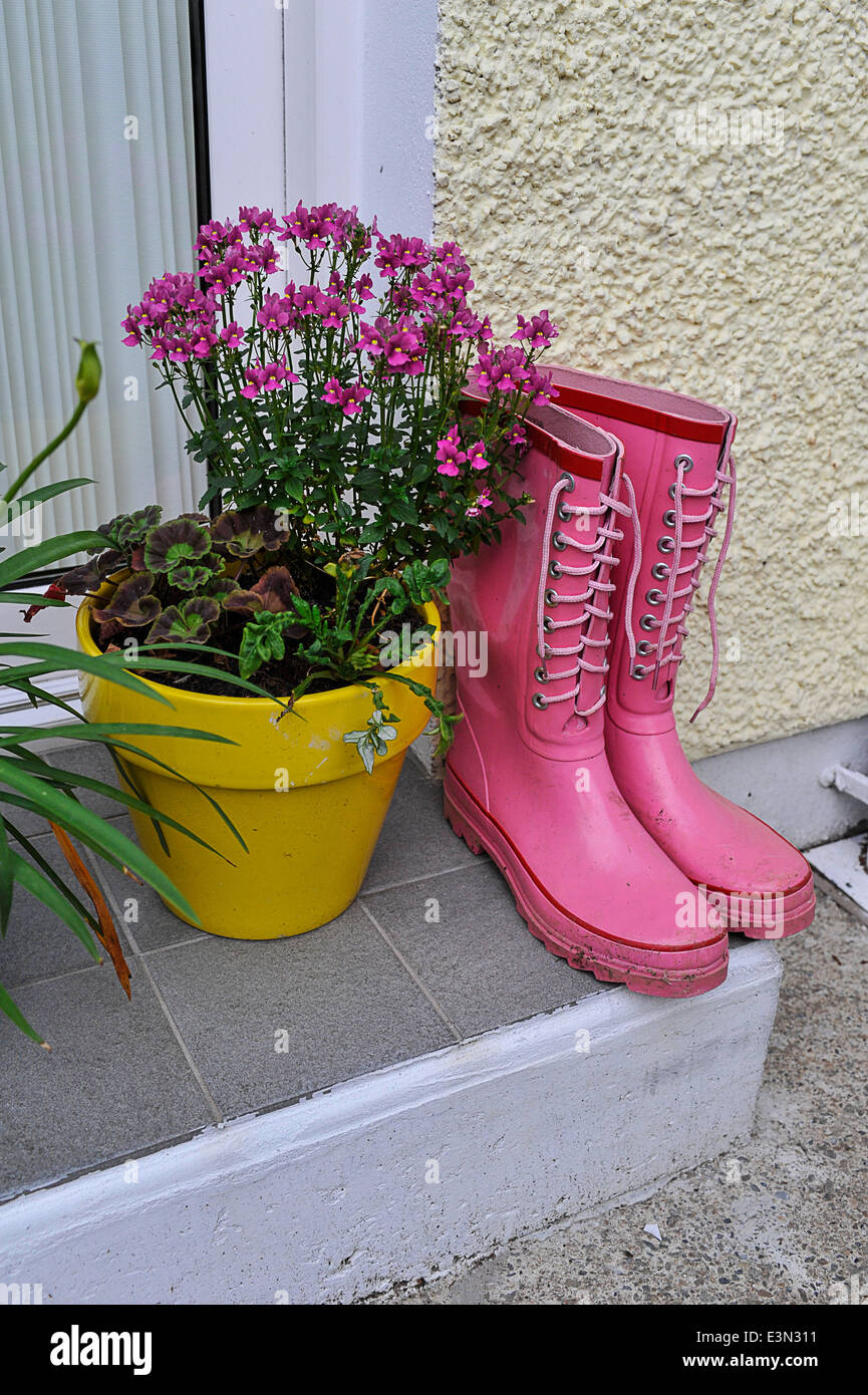 Garden essentials: gardening boots, pots, and flowers. Stock Photo