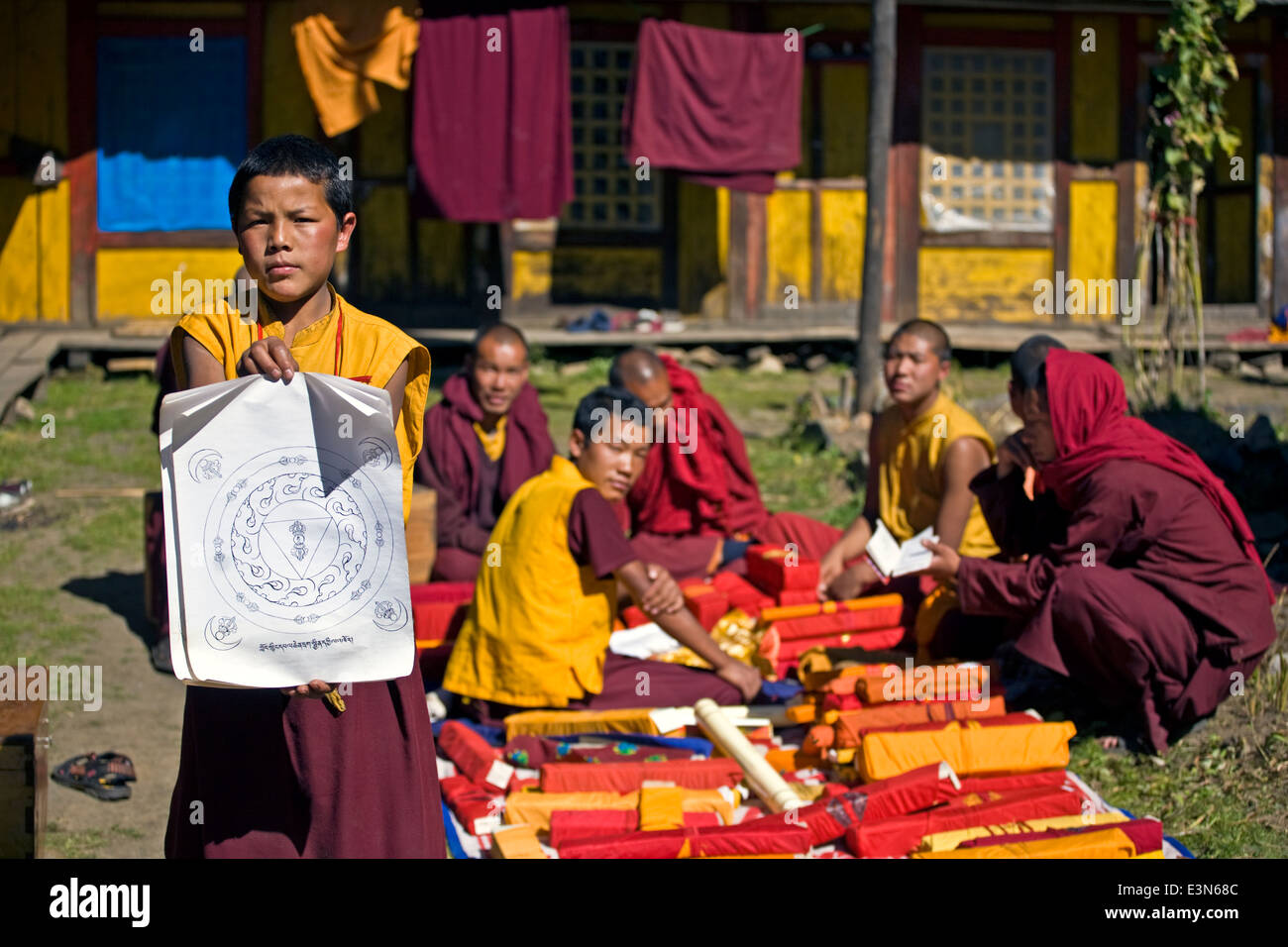 TIBETAN BUDDHIST MONKS study a mandala in a remote valley - NEPAL HIMALAYA Stock Photo