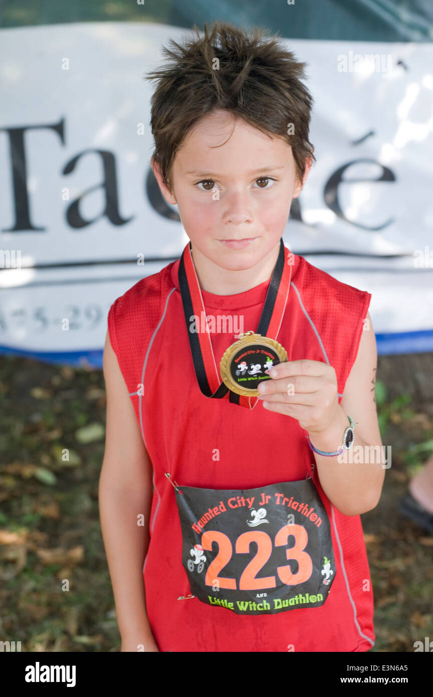 Six (6) year old boy proudly displays his medal for participating in