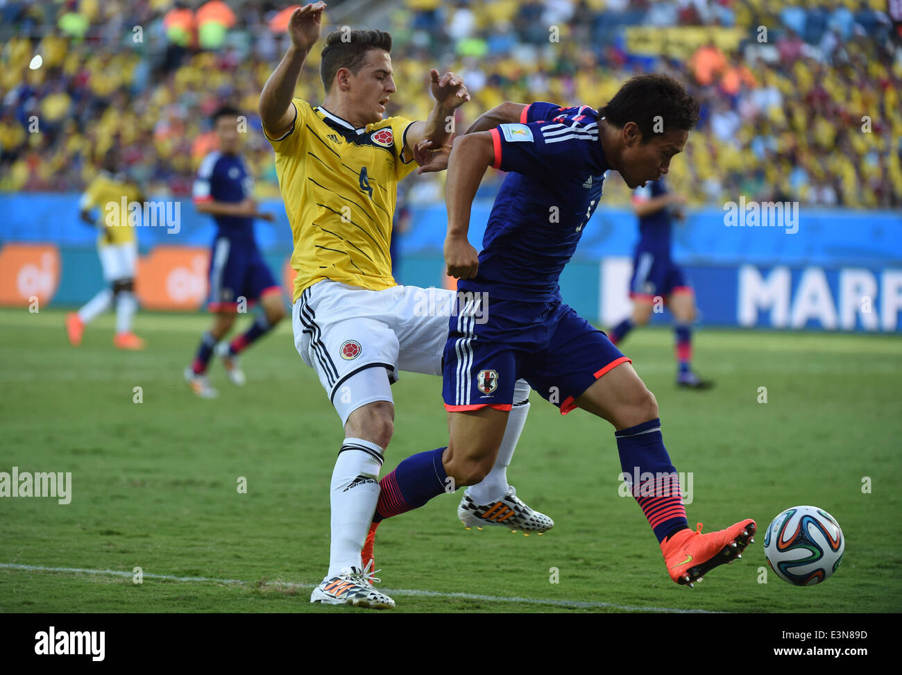 Cuiaba, Brazil. 24th June, 2014. Japan's Yuto Nagatomo (R) controls the ball during a Group C match between Japan and Colombia of 2014 FIFA World Cup at the Arena Pantanal Stadium in Cuiaba, Brazil, June 24, 2014. © Liu Dawei/Xinhua/Alamy Live News Stock Photo