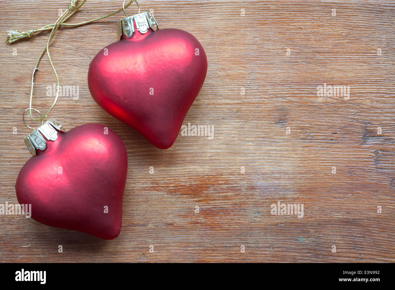 two toy hearts jointed by knot on vintage wooden table Stock Photo