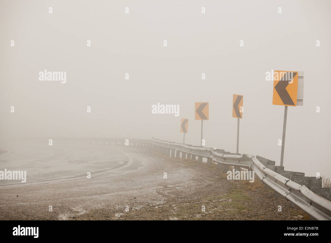 Empty road with arrow symbols against clear sky Stock Photo