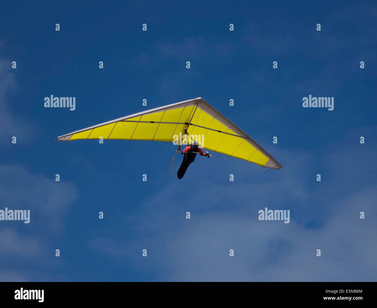 Low angle view of person hang-gliding against blue sky Stock Photo