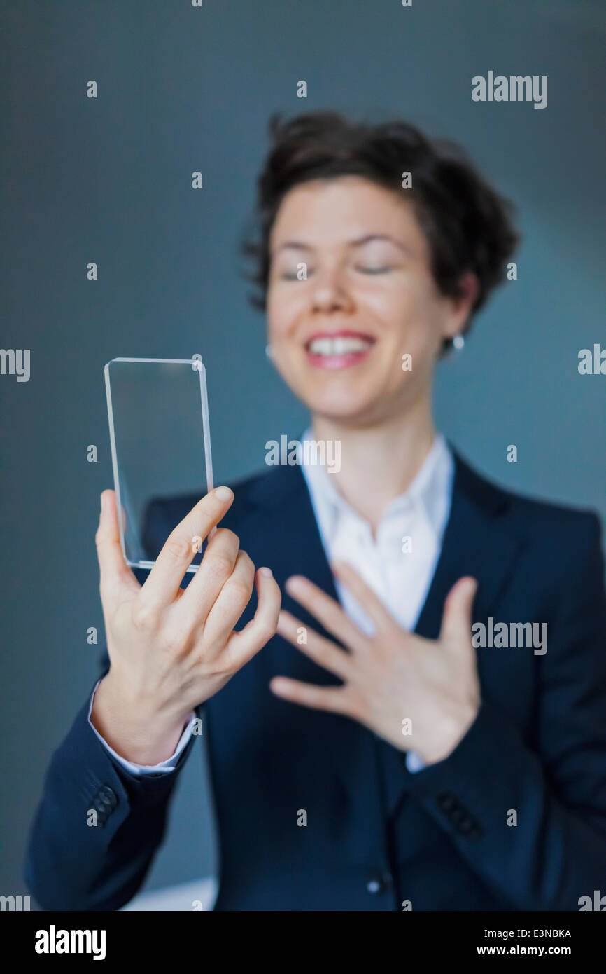 Satisfied Businesswoman Holding Blank Futuristic Transparent Smartphone Stock Photo
