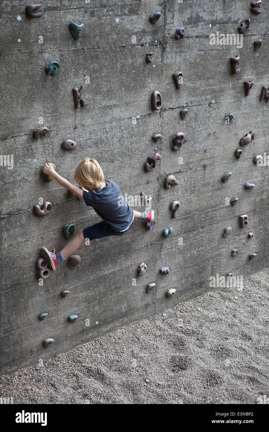 Full length rear view of boy climbing artificial rock Stock Photo