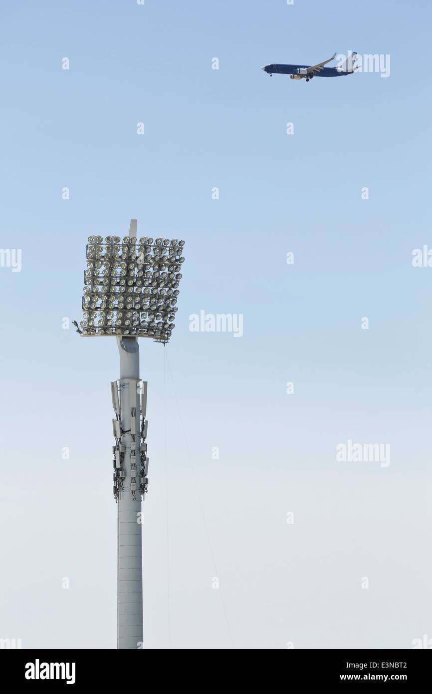 Floodlight and airplane against clear blue sky Stock Photo