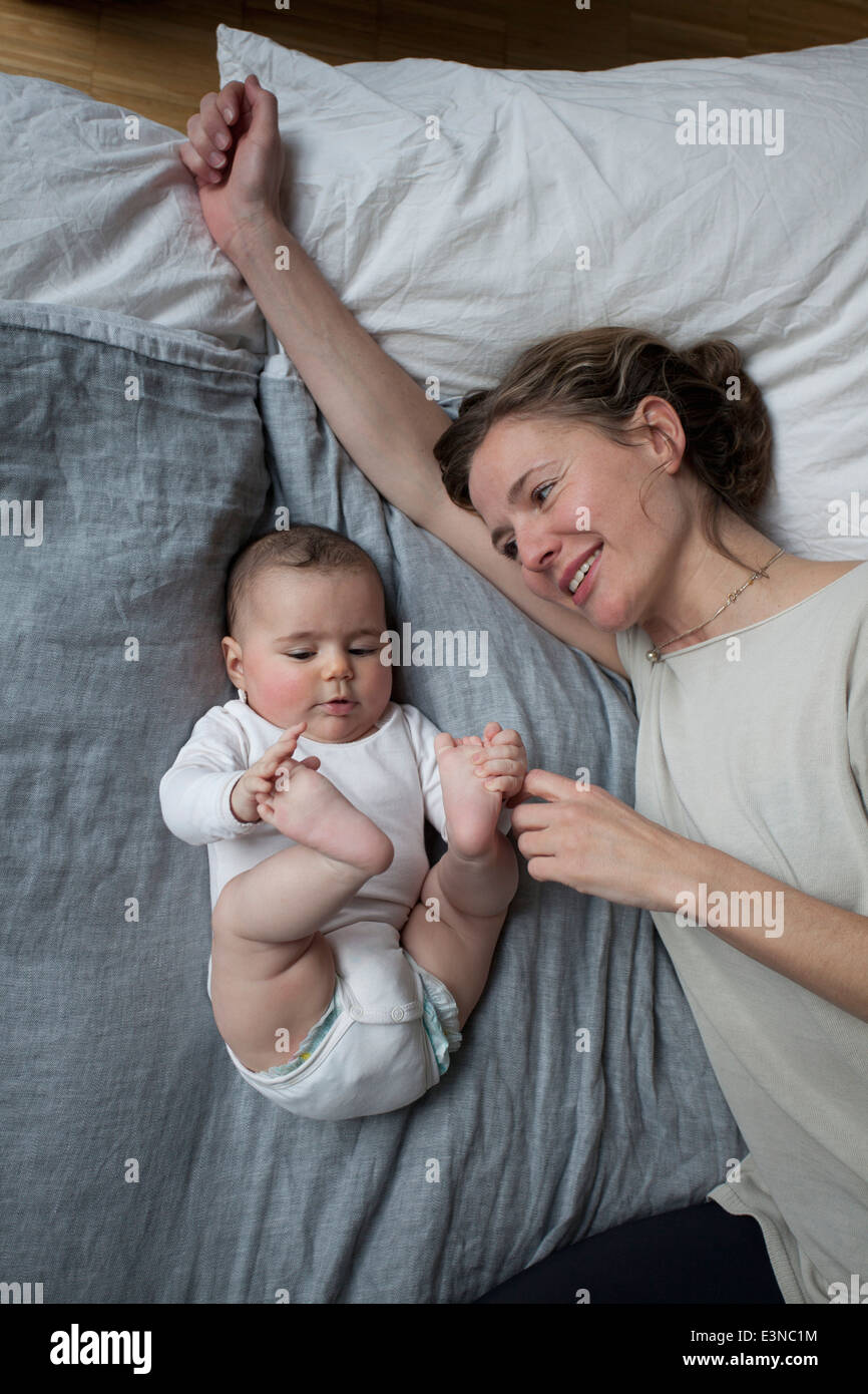 Directly above shot of smiling mother looking at baby girl at home Stock Photo