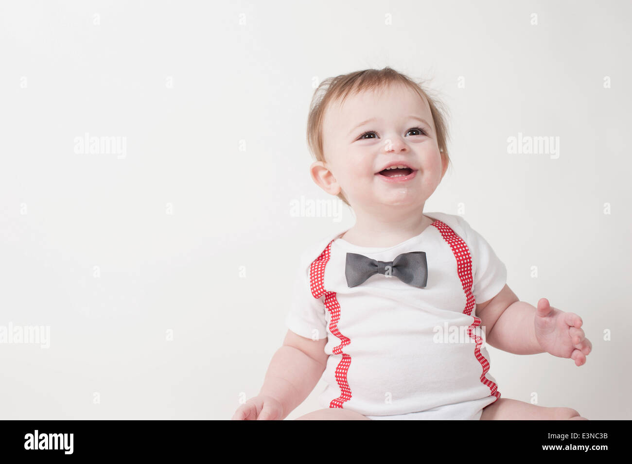 Happy baby boy looking away against white background Stock Photo