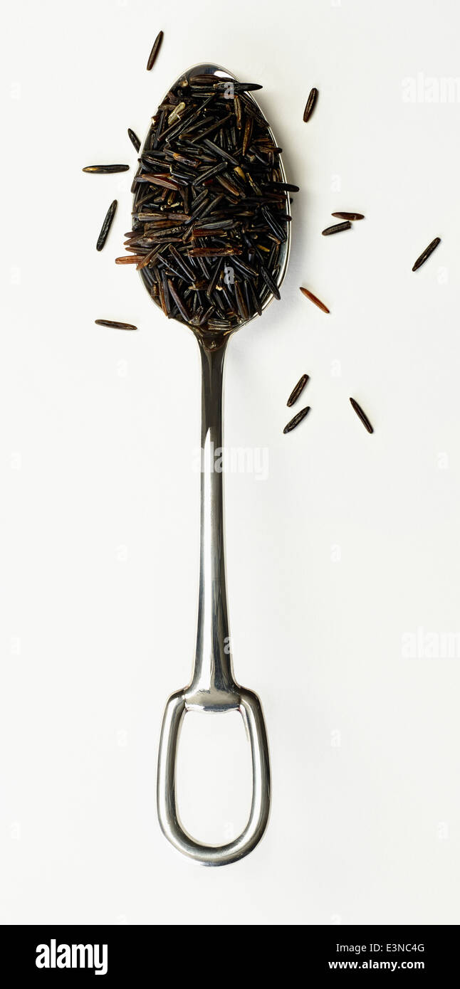 Directly above shot of black rice in spoon against white background Stock Photo