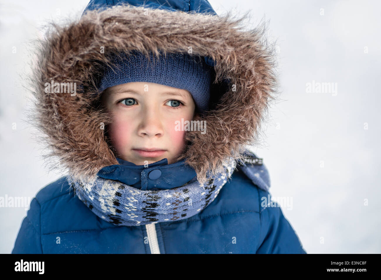 Thoughtful boy in warm clothing looking away outdoors Stock Photo