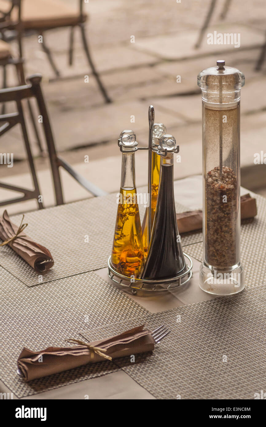 Seasoning bottles and napkins on table in restaurant Stock Photo