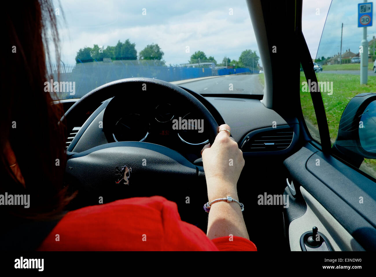 A female driving a car showing her right hand on the steering wheel England UK Stock Photo