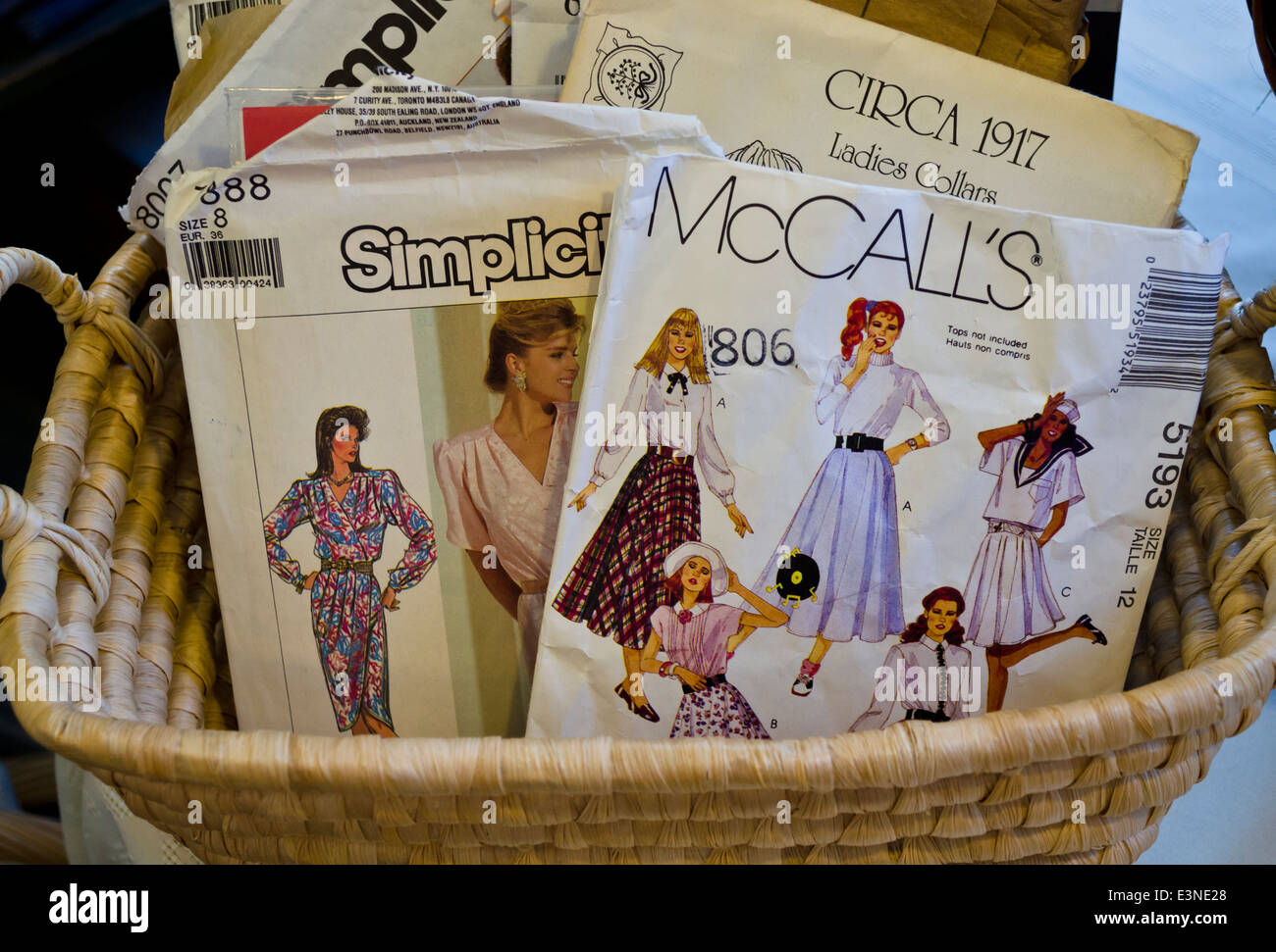Packages of women's sewing patterns from the 1980s.  McCalls's and Simplicity sewing patterns for ladies clothes in a basket. Stock Photo