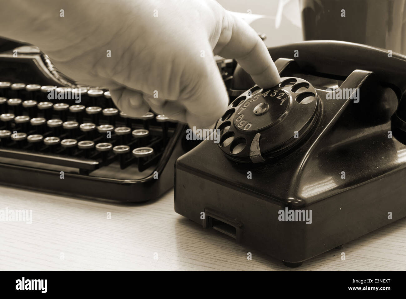 Vintage telephone and typewriter standing on the desk in the office