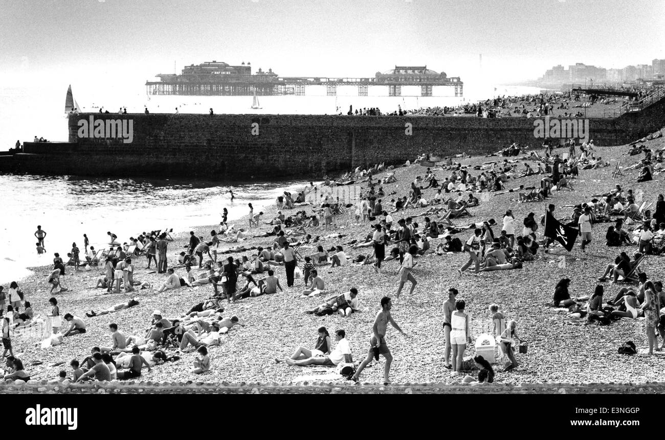 A busy Brighton beach with the West Pier in background on a hot July day in 1991 Stock Photo