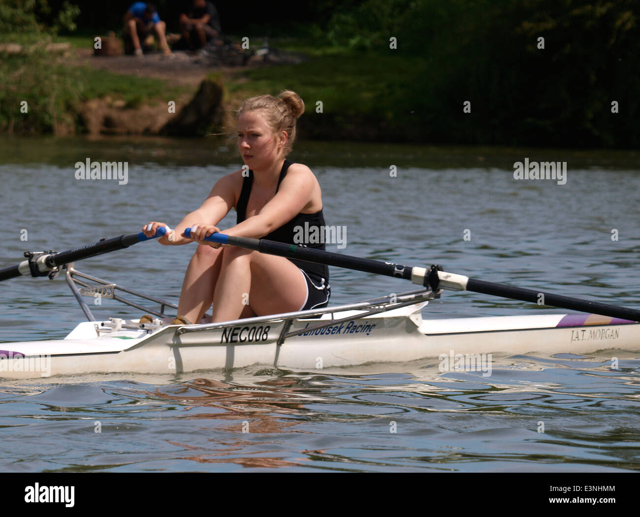 Young woman rowing a single scull on the River Thames at Oxford, UK