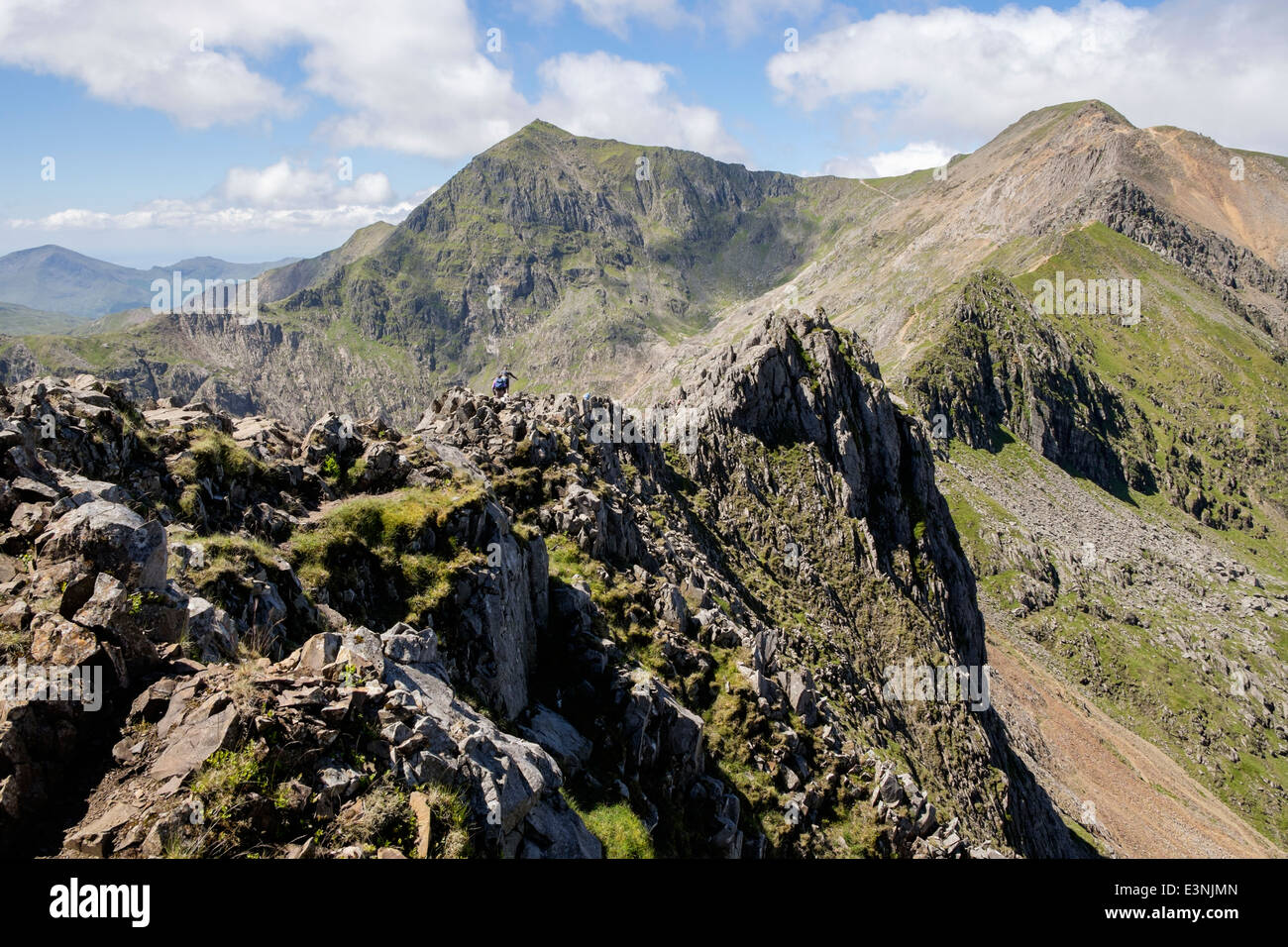 View along Crib Goch ridge scramble to Pinnacles with Crib y Ddysgl and distant Snowdon summit in the horseshoe. Snowdonia National Park Wales UK Stock Photo