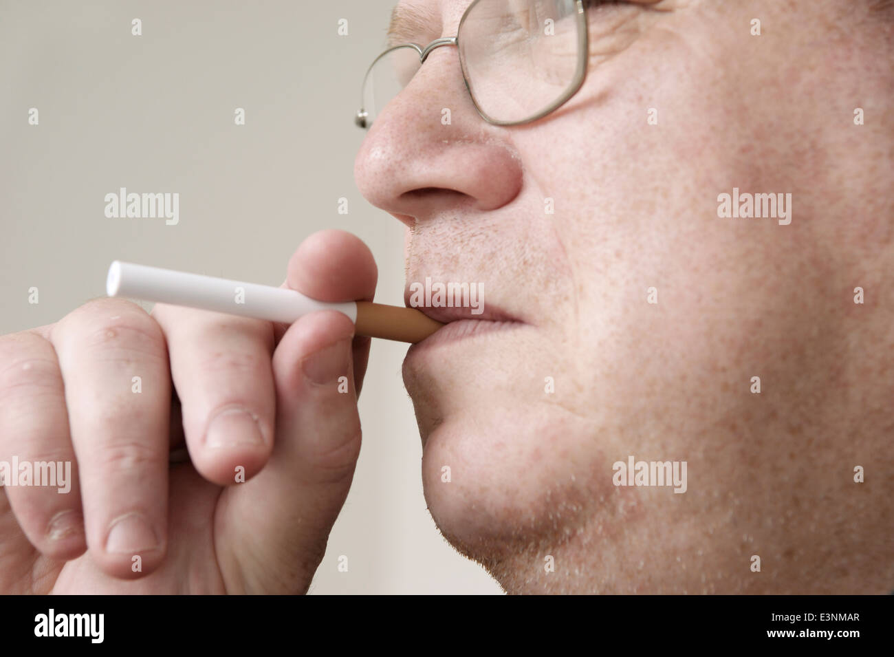 Man holding & smoking an electronic disposable E Cigarette (e-cigarette) Stock Photo
