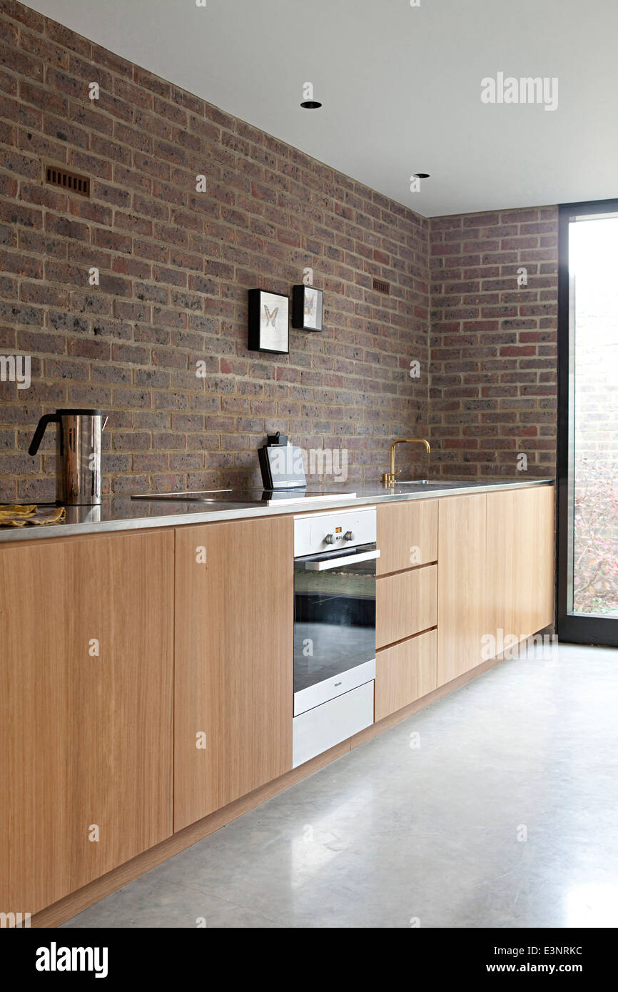 Duggan Morris house: Kings Grove, Peckham, London. Photograph shows the kitchen featuring oak surfaces and brass taps Stock Photo