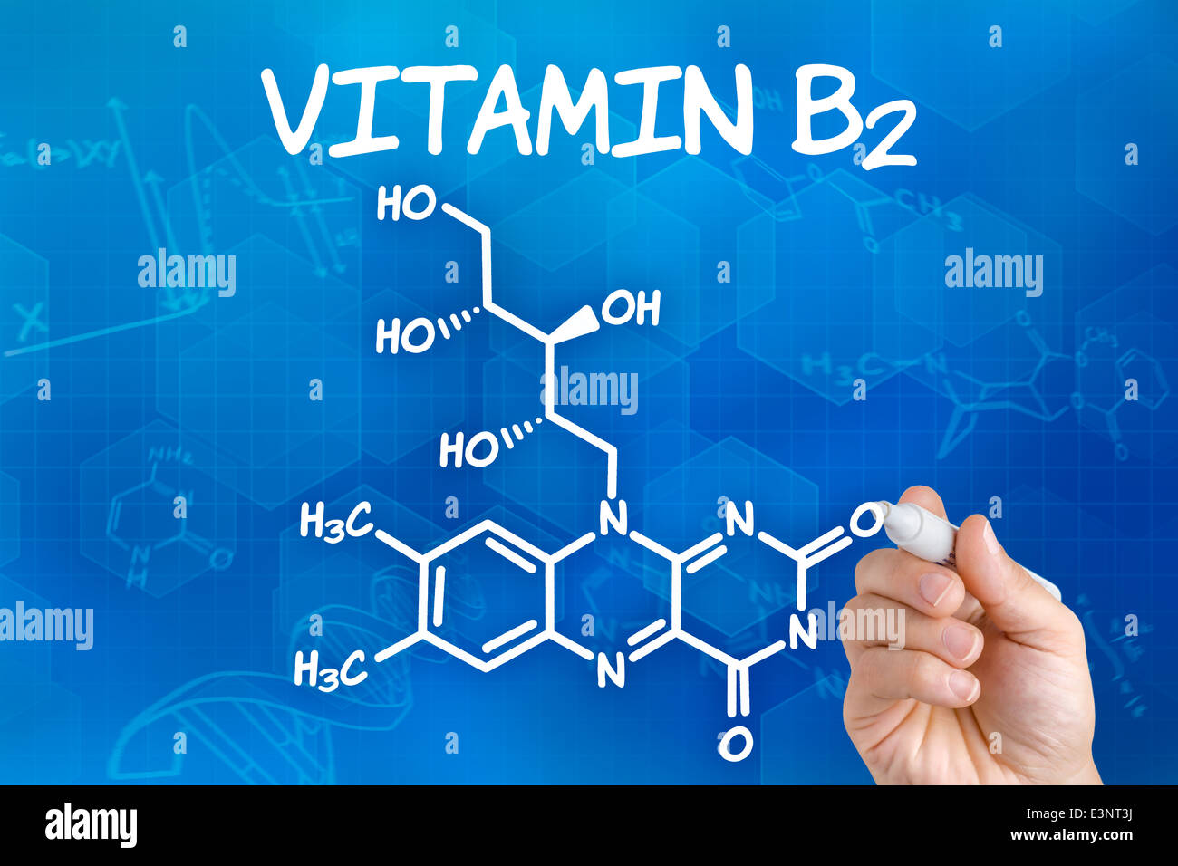 Hand with pen drawing the chemical formula of Vitamin B2 Stock Photo