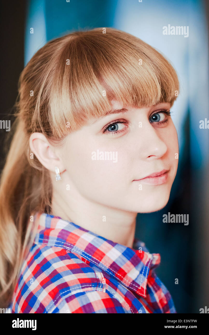 Close up portrait of a smiling young woman in shirt looking at camera ...