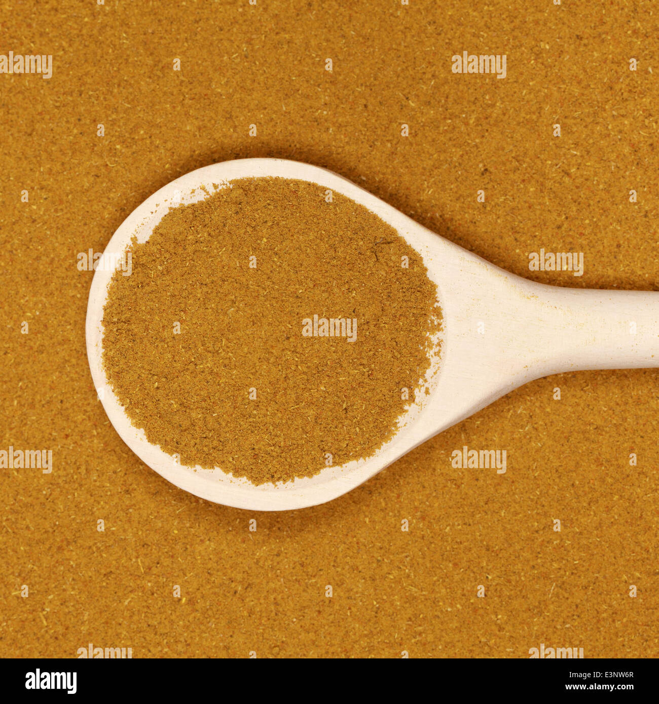A wooden spoon on curry forming a background Stock Photo