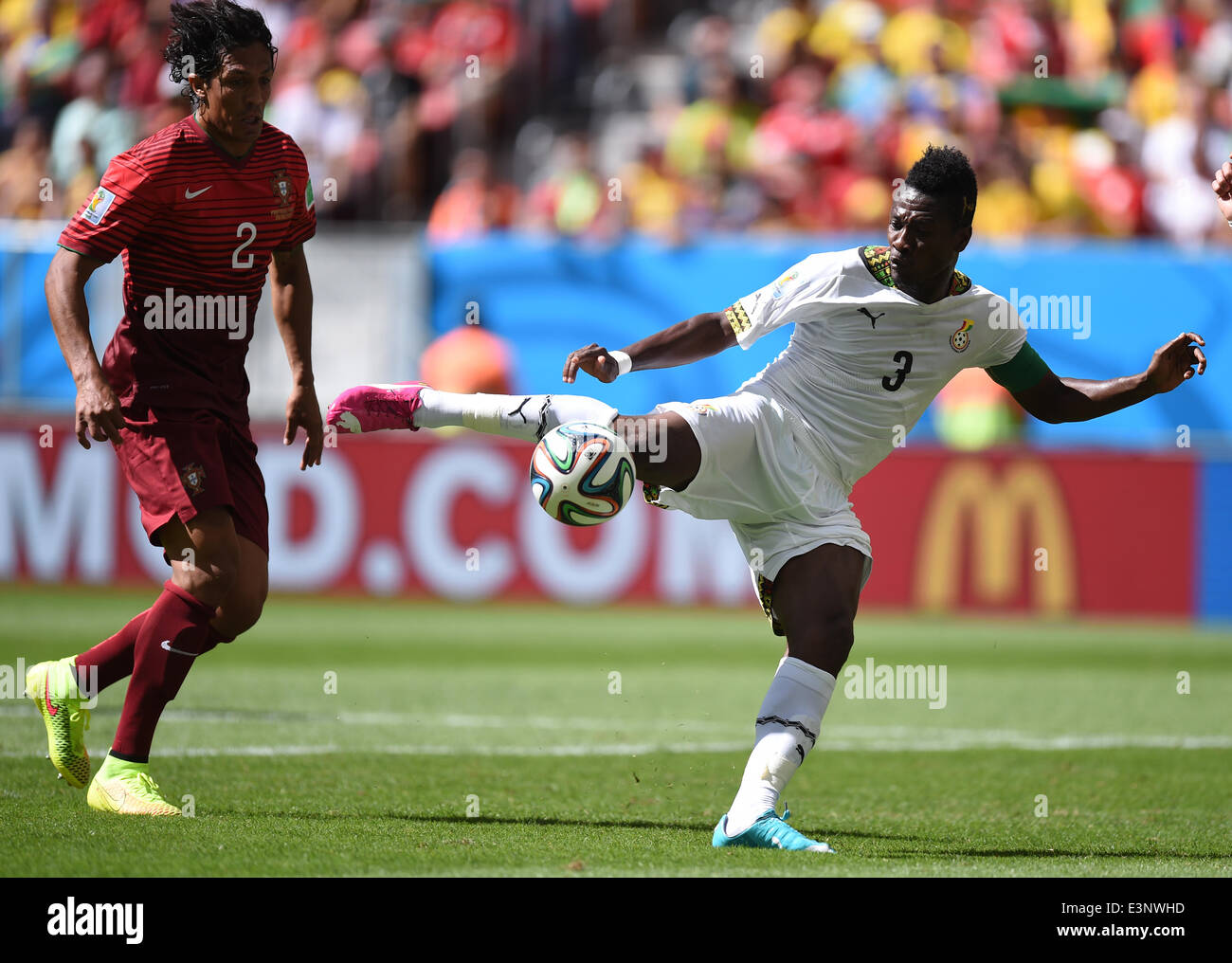Brasilia, Brazil. 26th June, 2014. Asamoah Gyan (R) of Ghana in action against Bruno Alves of Portugal during the FIFA World Cup 2014 group G preliminary round match between Portugal and Ghana at the Estadio National Stadium in Brasilia, Brazil, on 26 June 2014 Credit: © dpa picture alliance/Alamy Live News  Stock Photo
