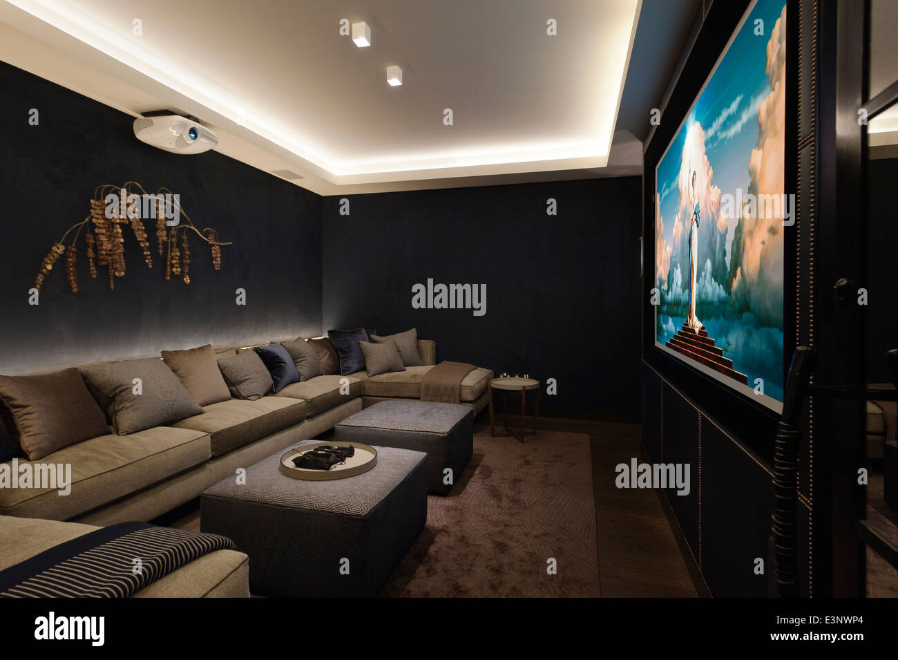 Chic home cinema in dark tones and extended sofa seating Stock Photo