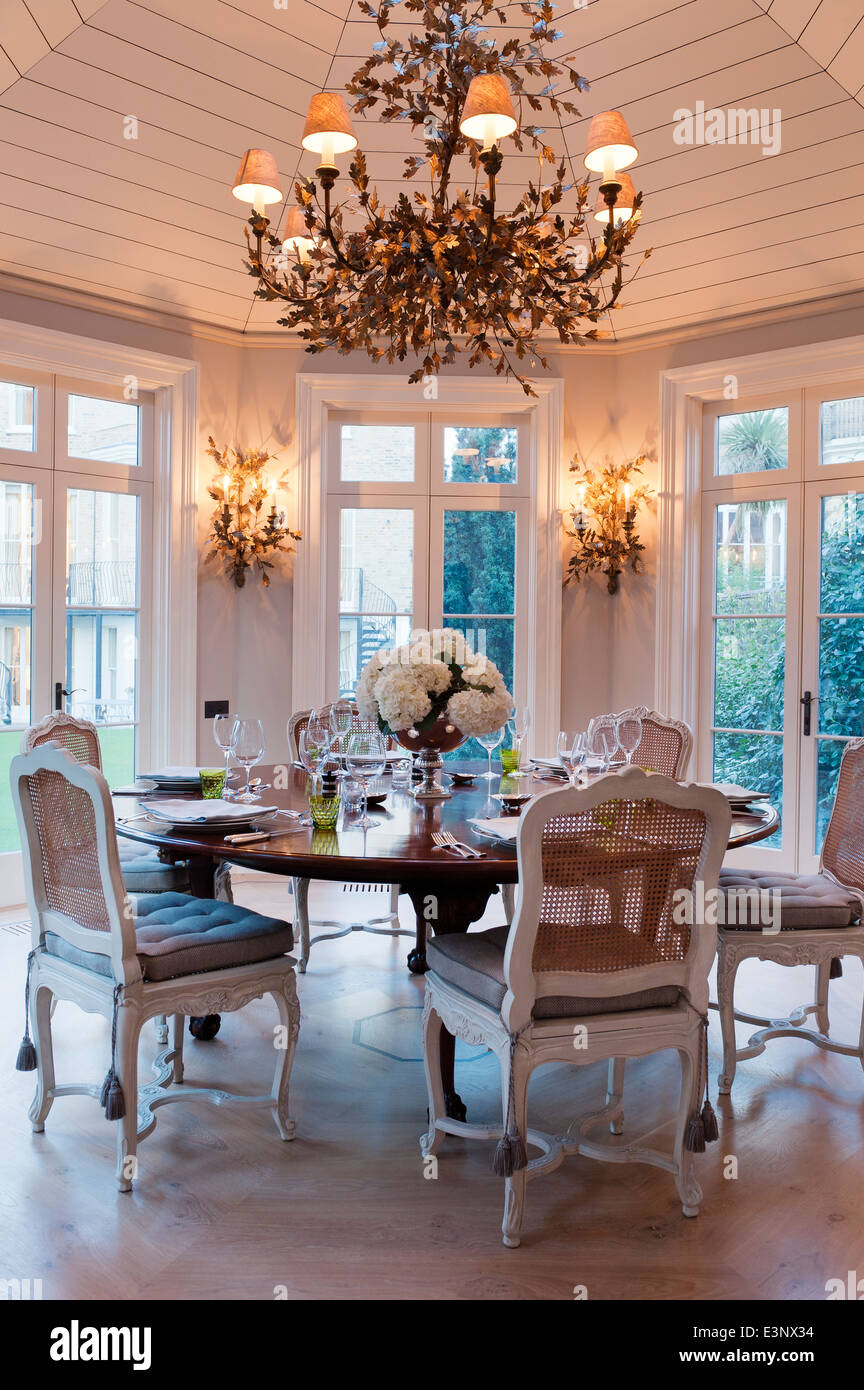 Circular laid Georgian table in octagonal pavilion with gilt Compiegne Leaf Chandelier and matching wall lights Stock Photo