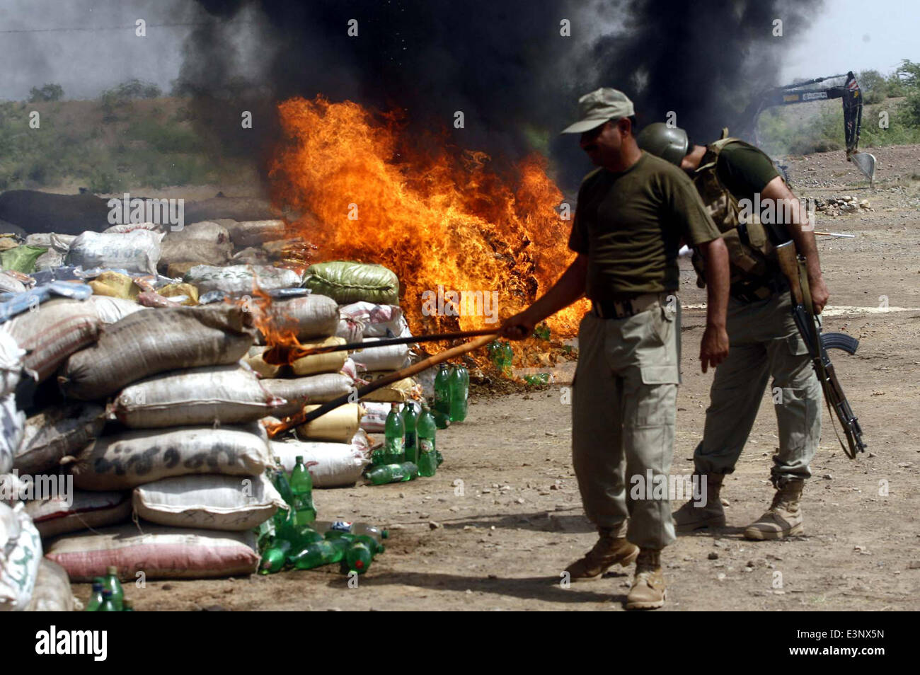 Anti-Narcotics Force (ANF) officials burn pile of confiscated drugs during ceremony on the occasion of International Day against Drug Abuse and Illicit Trafficking held in Khyber Agency on Thursday, June 26, 2014. As the world observes International Day against Drug Abuse and Illicit Trafficking. Pakistan annually seizes huge quantities of drugs which straddle a route from neighboring Afghanistan, destined for lucrative markets in the Middle East. Stock Photo