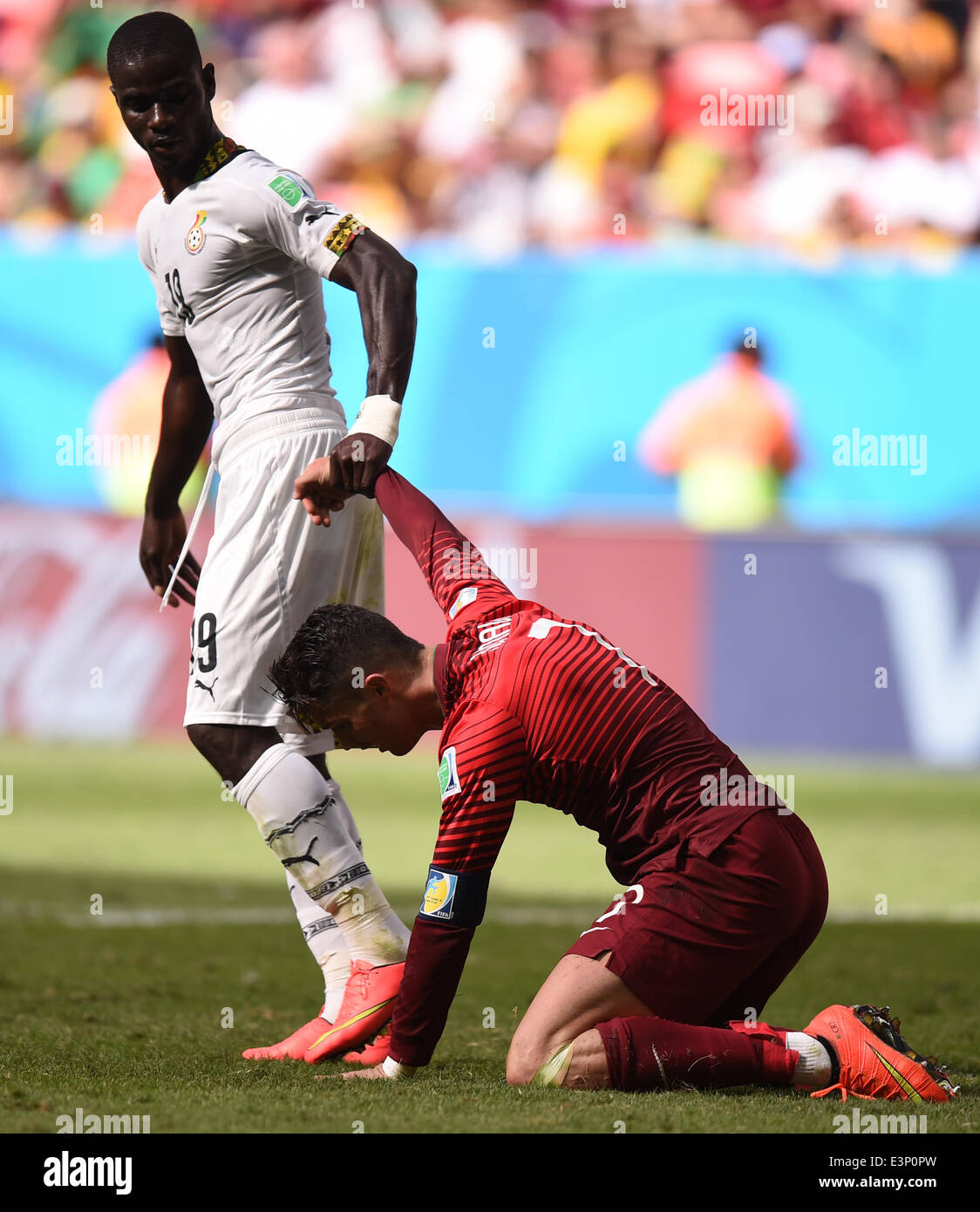 Brasilia, Brazil. 26th June, 2014. Jonathan Mensah (L) of Ghana helps up Cristiano Ronaldo (R) of Portugal during the FIFA World Cup 2014 group G preliminary round match between Portugal and Ghana at the Estadio National Stadium in Brasilia, Brazil, on 26 June 2014 Credit: © dpa picture alliance/Alamy Live News  Stock Photo