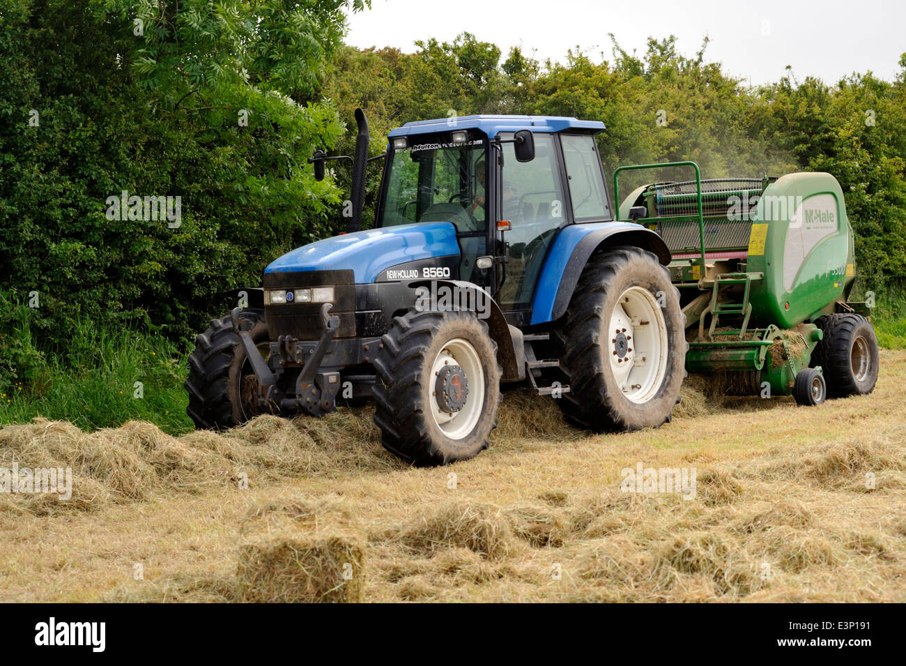 Tractor pulling machine, baler, for making big round bails of cut grass for hay or silage Stock Photo