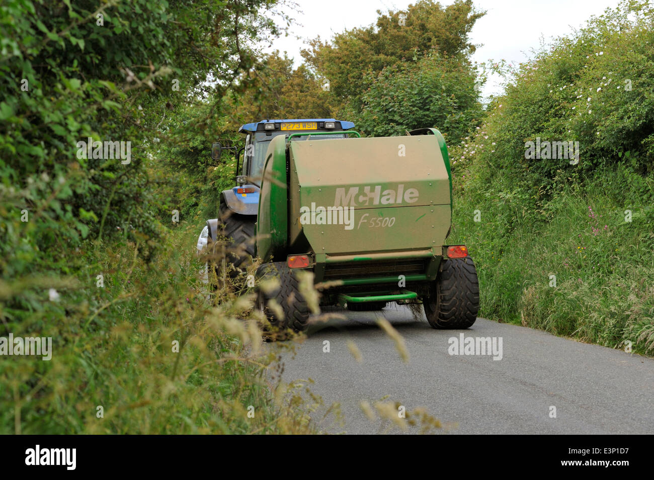 Farm machinery being moved down small country lane, UK Stock Photo