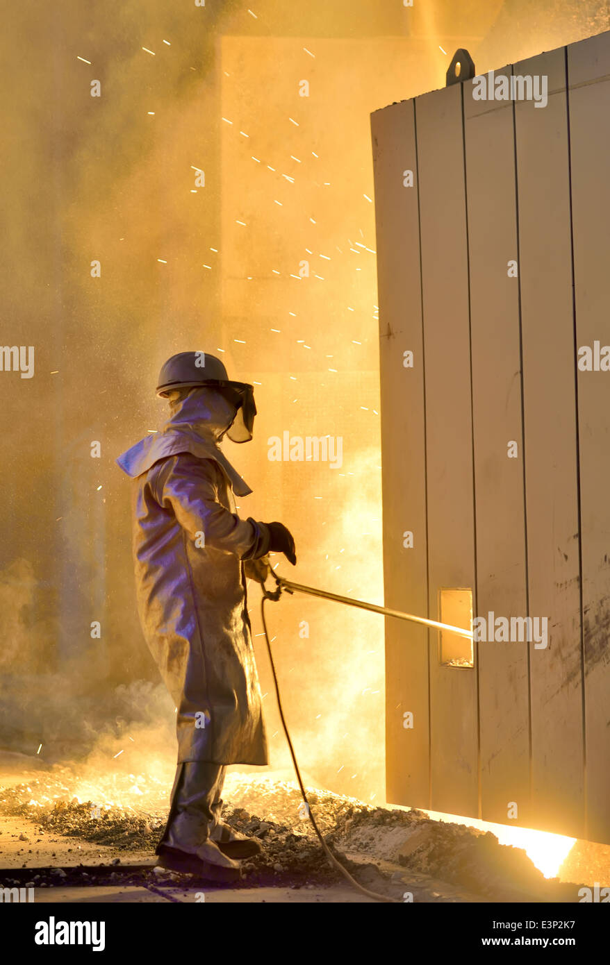 A steel worker takes a sample from oven Stock Photo